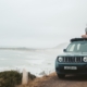man-sitting-on-top-of-Jeep-SUV-by-ocean-RocketChip-Jeep-Performance-Chips