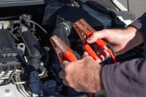 man-holding-jumper-cables-for-a-vehicle-RocketChip-monday-morning-car-care